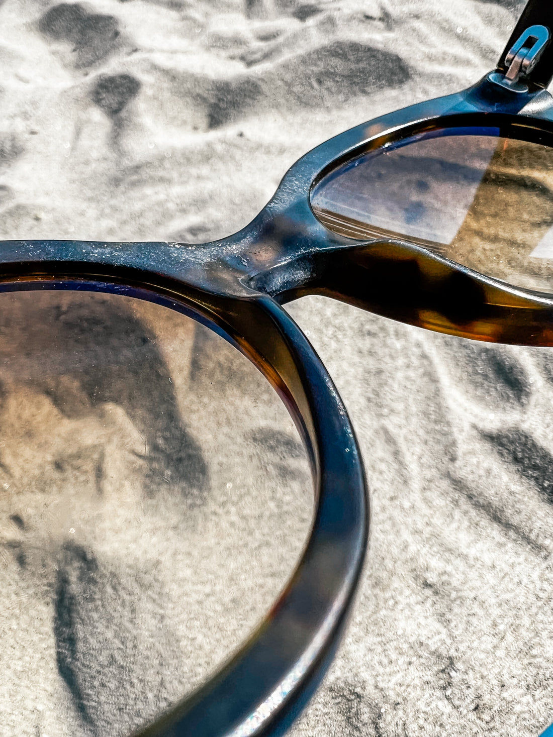 a image of very dirty, stained and smeared glasses at the beach in summer, sunglasses